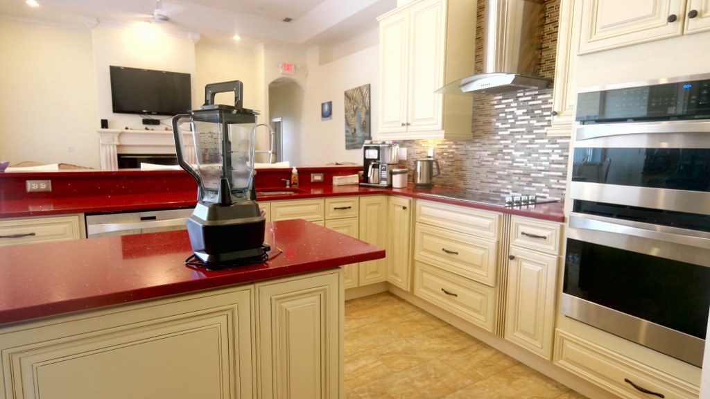 Open kitchen with wide counters, double ovens, and a fireplace beyond