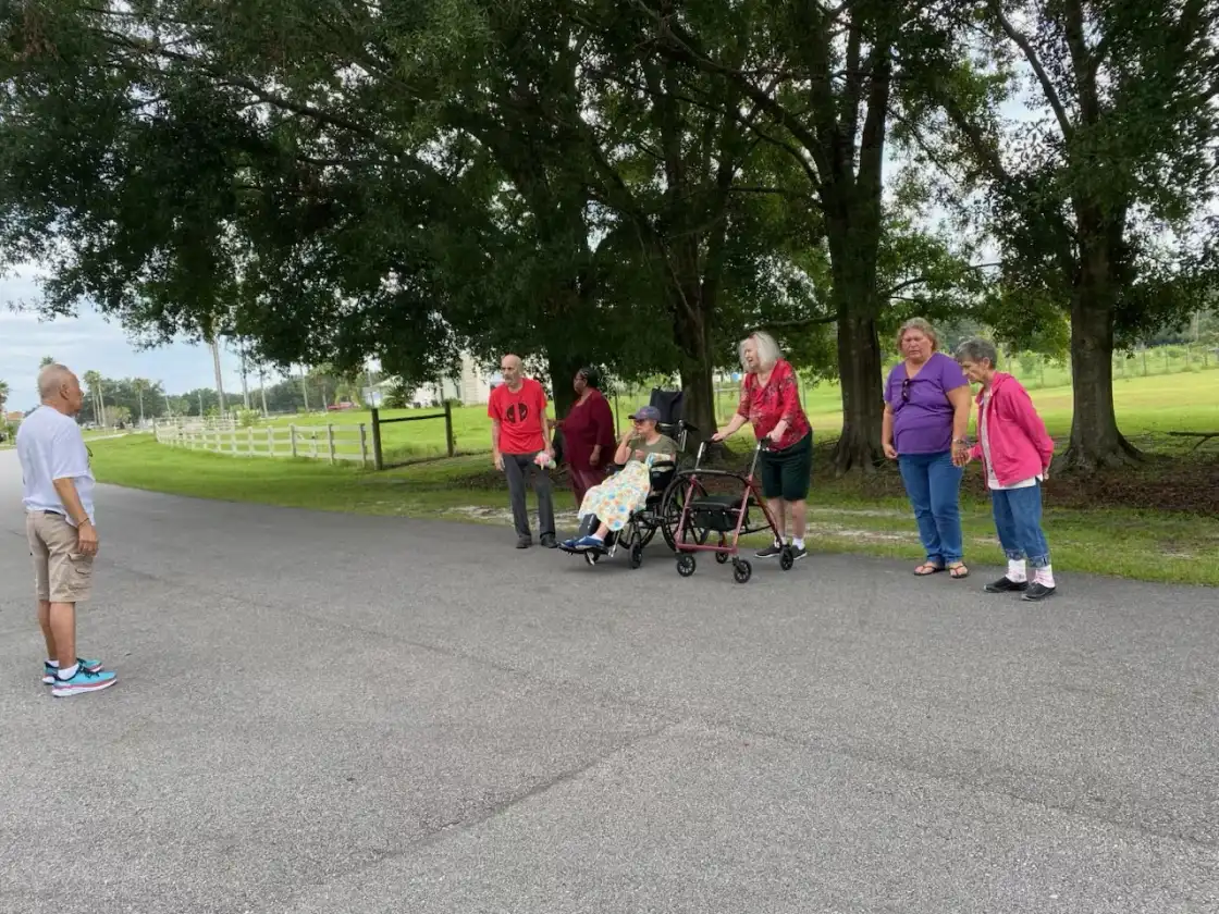 Residents enjoying an outdoor walk with mobility aids