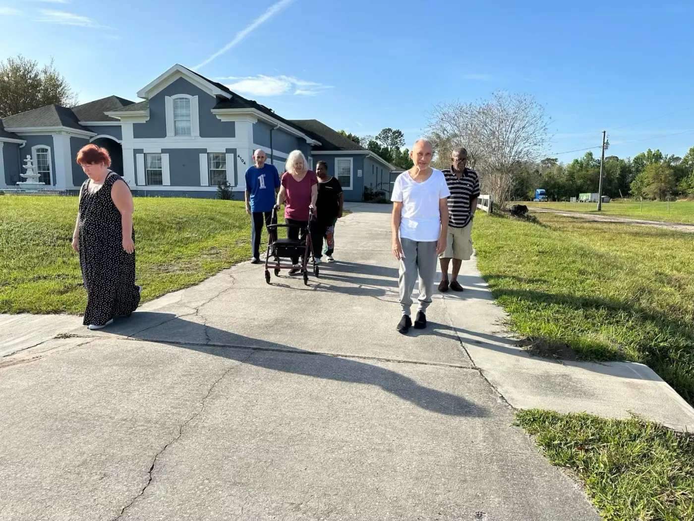 Residents walking together outside the blue-and-white home