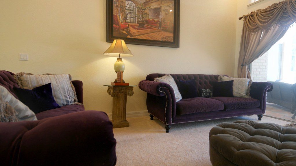 Sitting room with velvet sofas and lamplight