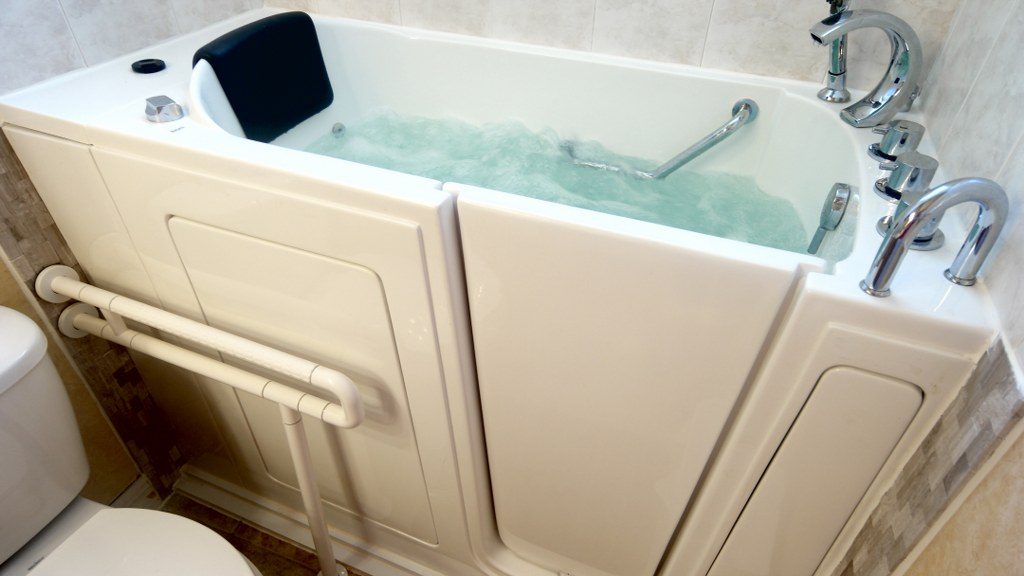 Walk-in bathtub with a side door, seat, and grab rails